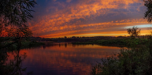 the setting sun beautifully painted the clouds in scarlet on a warm summer day