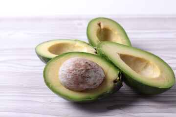 avocado halves on white wooden surface of a table