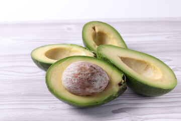 avocado halves on white wooden surface of a table