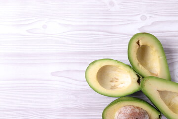 avocado halves on white wooden surface of a table