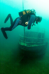 Scuba diver exploring the ship wreck in a fresh water lake. © frantisek hojdysz