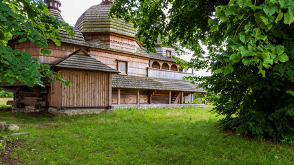 Old antique wooden building behind trees. Former Greek-Catholic church architecture built in year 1713 and renovated nowadays. Nowe Brusno village, Poland, Europe...