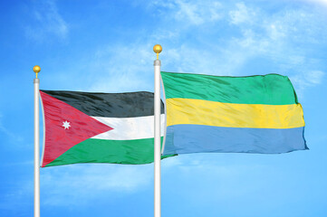 Jordan and Gabon two flags on flagpoles and blue cloudy sky