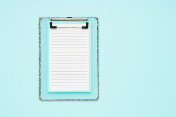 Blank clipboard mockup on light blue color background. Back to school, deadline, morning concept. Top view, copy space.