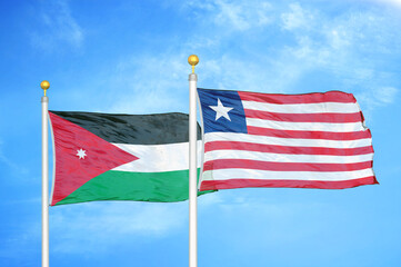 Jordan and Liberia two flags on flagpoles and blue cloudy sky