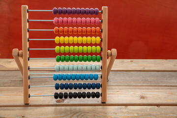 School abacus with colorful beads on wooden desk, close up view