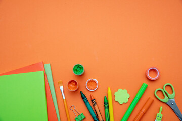 School supplies on orange color background, top view, copy space