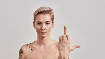 No way. Portrait of arrogant half naked tattooed woman with pierced nose and short hair showing...