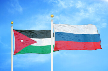 Jordan and Russia two flags on flagpoles and blue cloudy sky