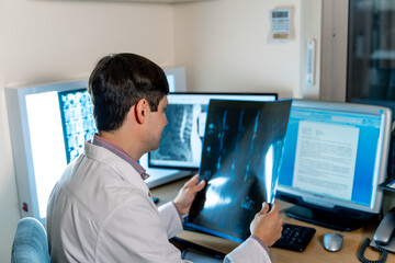 Doctor radiologist sitting near computer. Diagnosis at monitor. View from the back. Neurosurgery concept.
