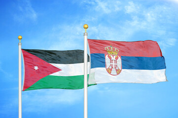 Jordan and Serbia two flags on flagpoles and blue cloudy sky
