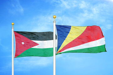 Jordan and Seychelles two flags on flagpoles and blue cloudy sky
