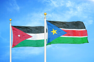 Jordan and South Sudan two flags on flagpoles and blue cloudy sky