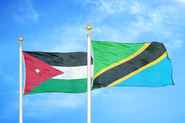 Jordan and Tanzania two flags on flagpoles and blue cloudy sky