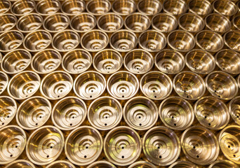an abstract perspective industrial close-up background of shiny brass metal threaded hexagonal...