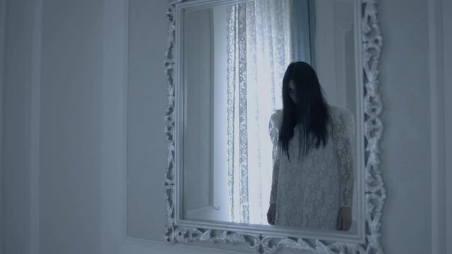 Reflection of female ghost appearing in mirror, paranormal activity, mystery