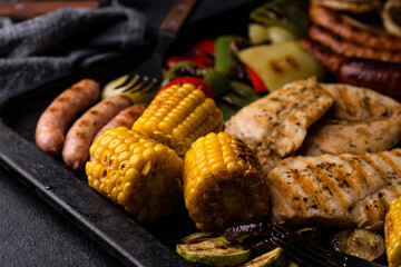 Grilled sausages, meat, and vegetables.