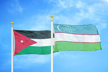 Jordan and Uzbekistan two flags on flagpoles and blue cloudy sky