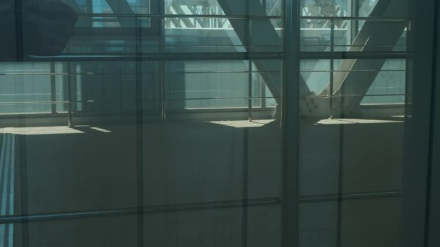 Legs of metro commuters walking in bridge. view through the window.