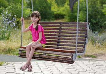 Foto op Canvas schattig meisje op een schommel in het park © Albert Ziganshin