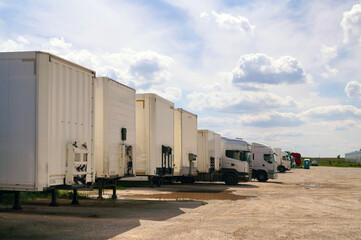 Fototapeta na wymiar Maneuvering area for trucks. Various types of vehicles waiting to be unloaded and loaded.