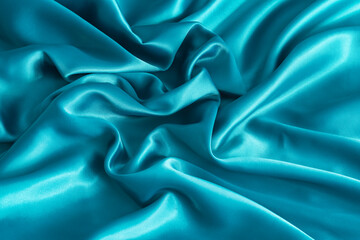 Fototapeta premium Folded aqua blue satin texture. Light blue satin fabric close up. Abstract background of luxury satin textile