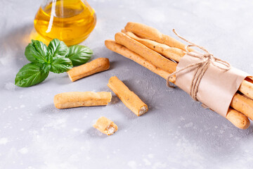 Grissini bread sticks with basil leaves and olive oil