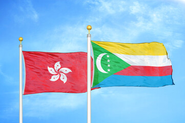 Hong Kong and Comoros two flags on flagpoles and blue cloudy sky