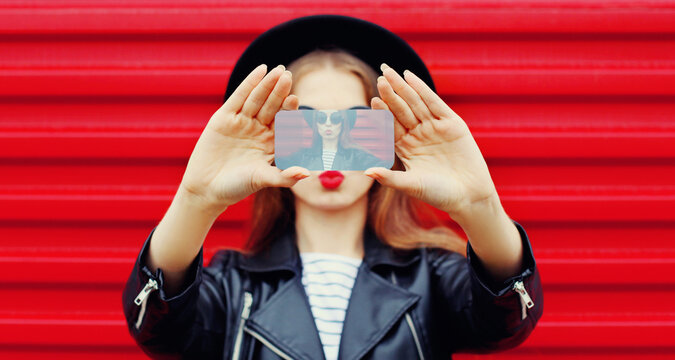 Close-up woman taking selfie picture by smartphone over wall background
