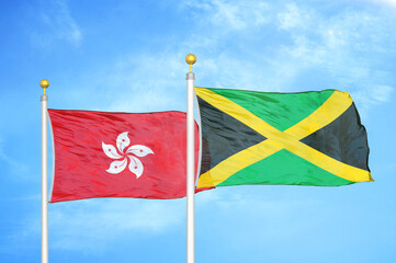 Hong Kong and Jamaica two flags on flagpoles and blue cloudy sky