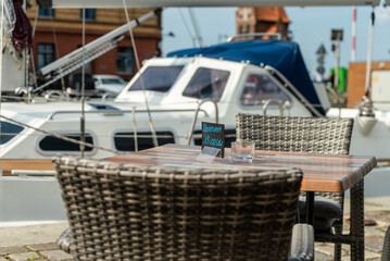 Sailing yacht in the harbor with a table and two chairs an a reserved sign in front of it