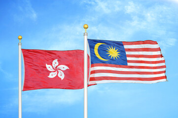 Hong Kong and Malaysia two flags on flagpoles and blue cloudy sky