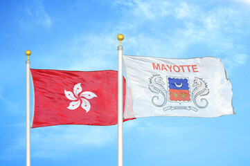Hong Kong and Mayotte two flags on flagpoles and blue cloudy sky