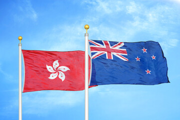 Hong Kong and New Zealand two flags on flagpoles and blue cloudy sky