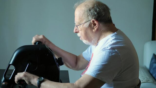 elderly man does exercises by training his arms