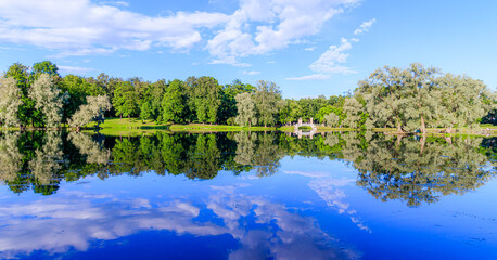 Panorama of summer Park . Park Russia . Public park. Mirror image in the Park by the water with the bridge . Summer Park. The lake in the Park. City park. Beautiful summer landscape.