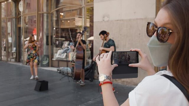 trio strings musical band playing music outside in the street in pedestrian zone in pandemic time