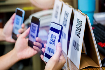Many customer hands holding smart phone to scan Qr code payment and barcode. The concept of digital...