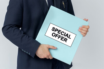 A businessman holds a folder with documents, the text on the folder is - SPECIAL OFFER