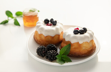 cheese pancakes with blueberries, blackberries and honey on a white table