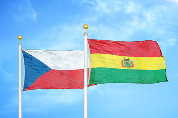 Czech and Bolivia two flags on flagpoles and blue cloudy sky