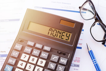 Office table with pen, glasses and calculator with MONEY text