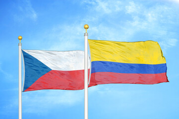 Fototapeta na wymiar Czech and Colombia two flags on flagpoles and blue cloudy sky