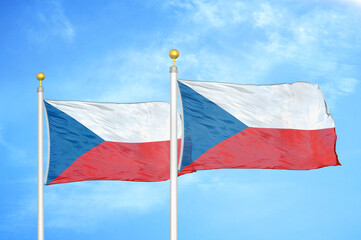 Czech two flags on flagpoles and blue cloudy sky