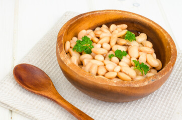 Boiled white beans in wooden bowl. Photo