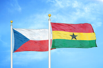Czech and Ghana two flags on flagpoles and blue cloudy sky