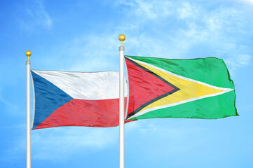 Czech and Guyana two flags on flagpoles and blue cloudy sky
