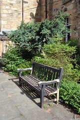 Close Up of Old Empty Wooden Bench in Churchyard Garden 