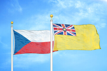 Czech and Niue two flags on flagpoles and blue cloudy sky