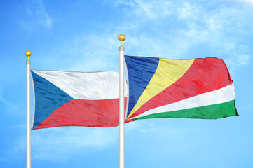Czech and Seychelles two flags on flagpoles and blue cloudy sky